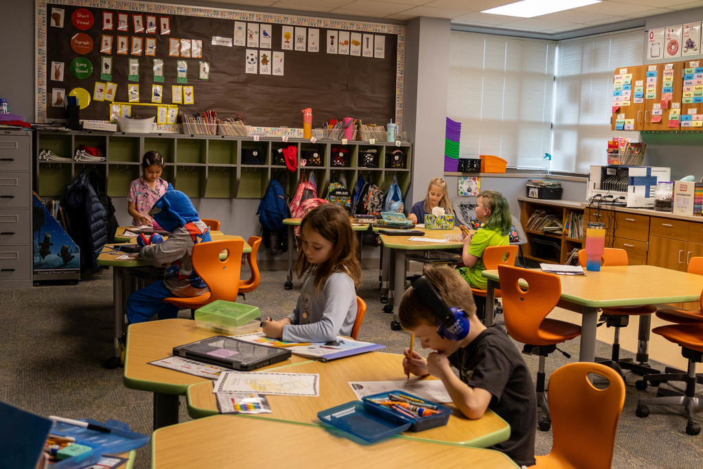 Kids in classroom coloring.