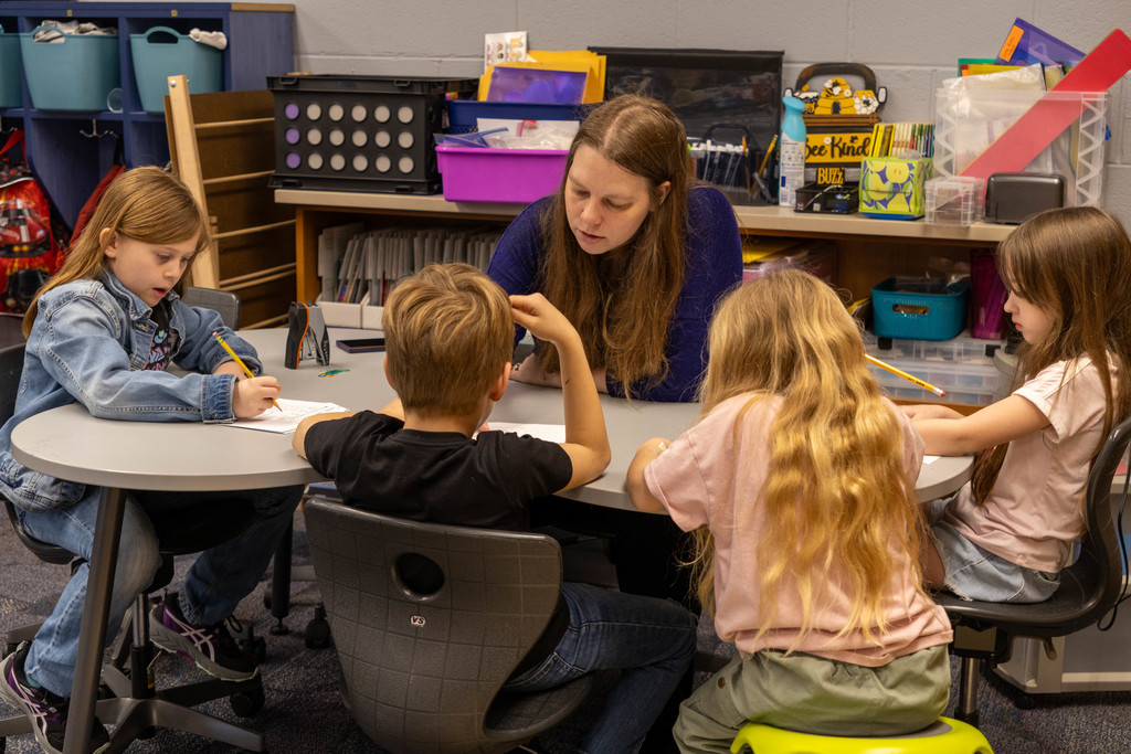 Teacher helping kids.