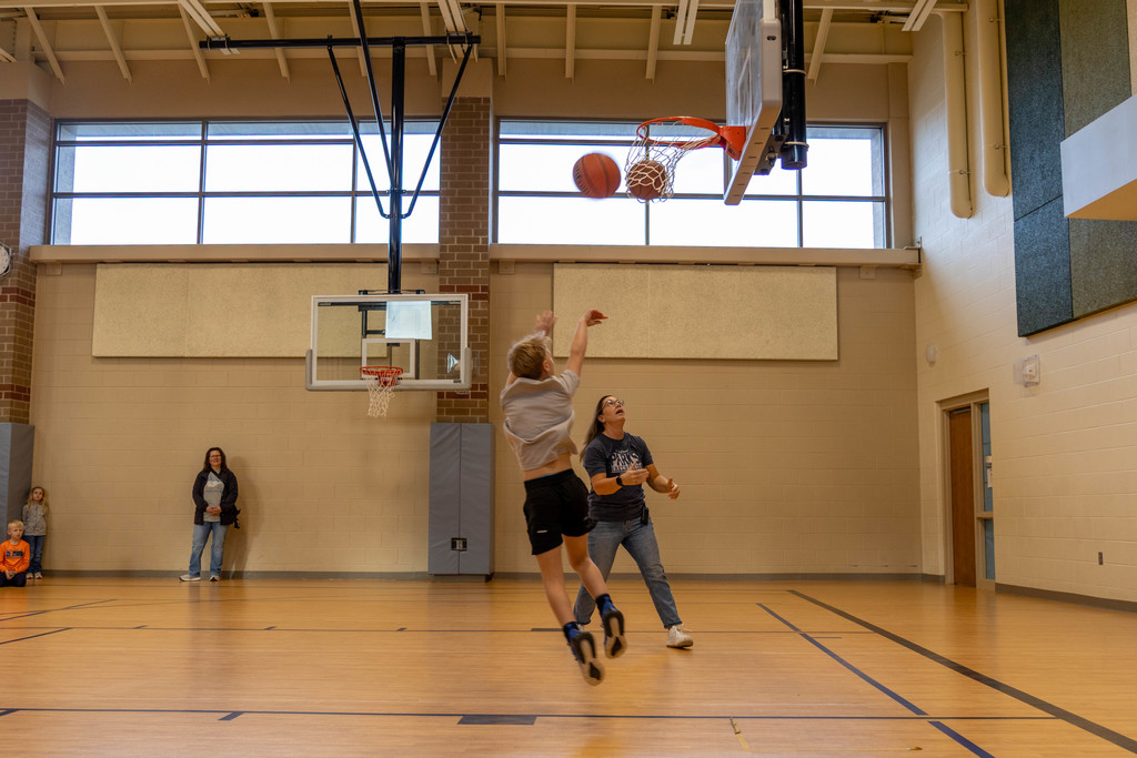 Principal and student playing basketball.