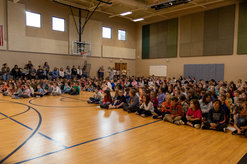 Gymnasium full of kids for assembly.