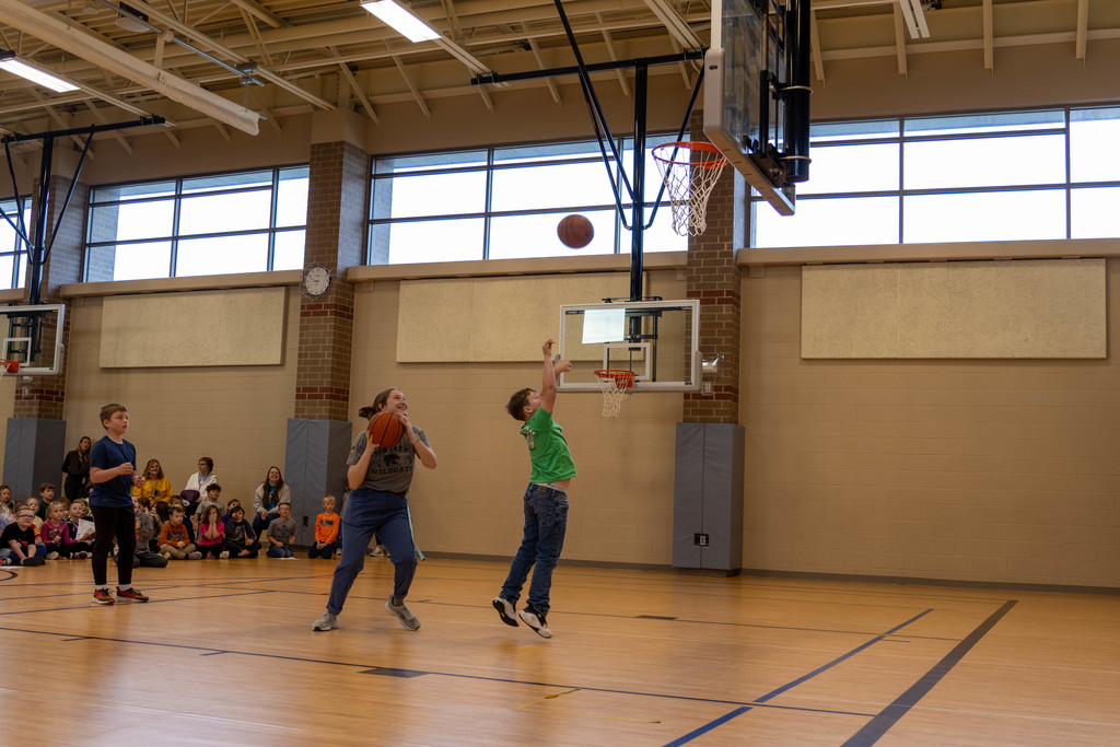 Kid and teacher playing basketball.