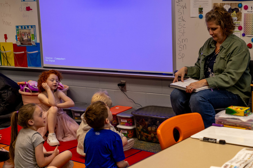 Teacher with kids on the carpet.