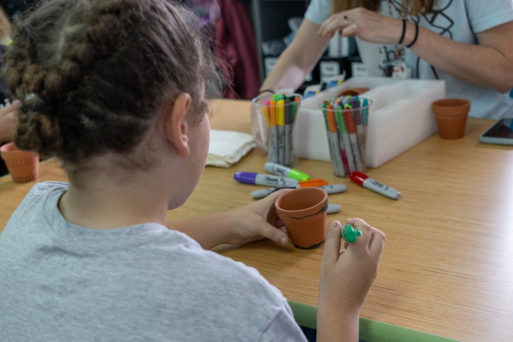 Kid coloring on potted plant.