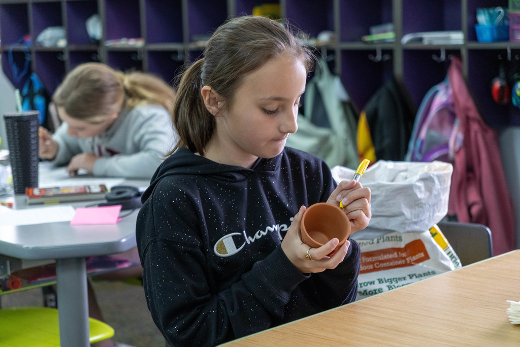 Kid coloring on pot.