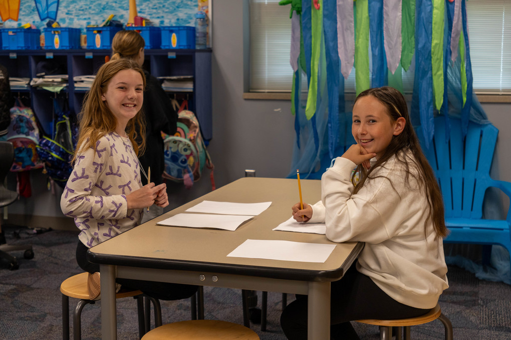 Two kids smiling while working.