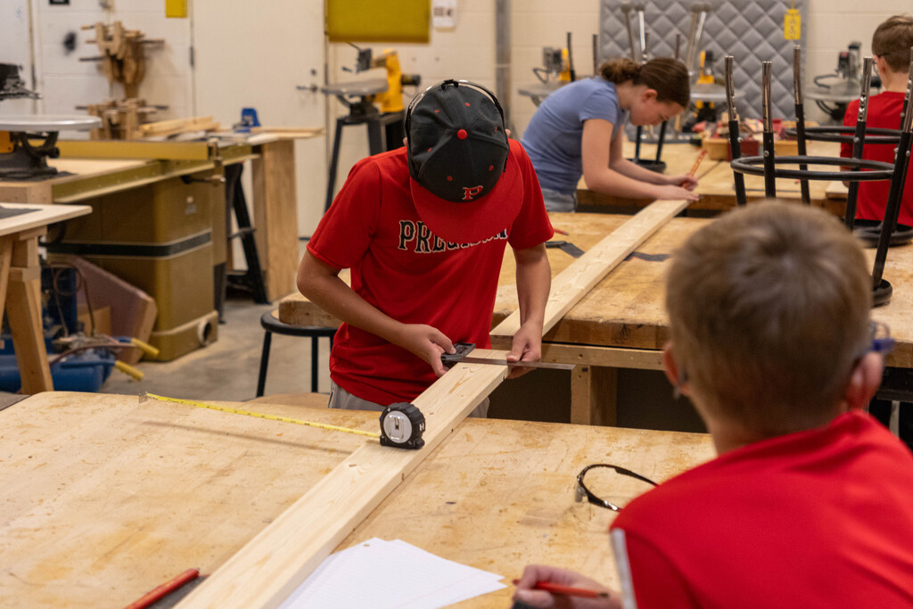 This image shows another student using a small square to mark his cut line.