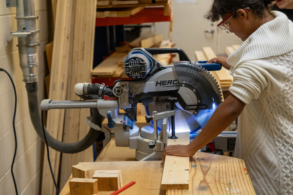 A student at Ottawa Middle School using a miter saw in woods class.