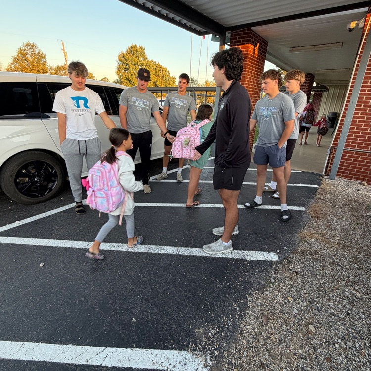 Eagle baseball players greeting bus riders