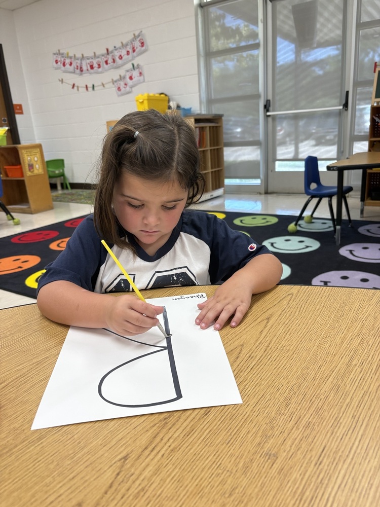 Pre-K student working on fine motor skills tracing letters