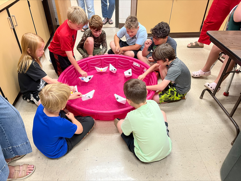 students testing paper boats