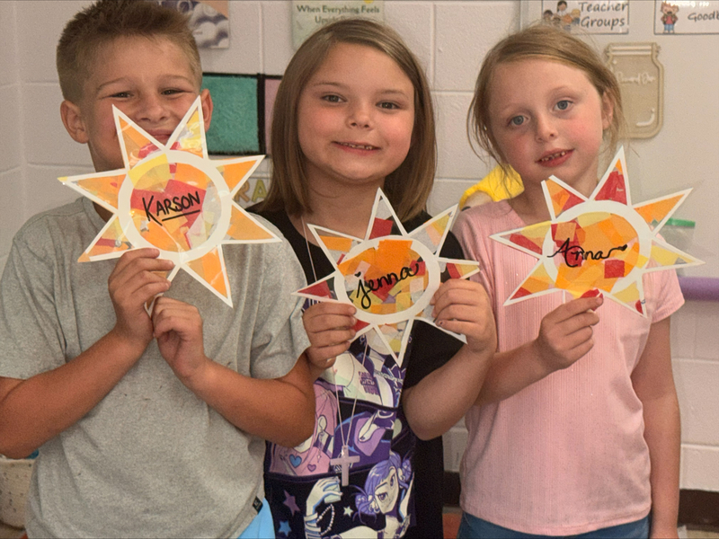 students holding art work