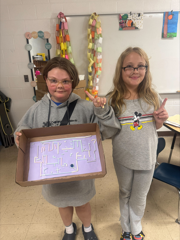 students hold a marble maze