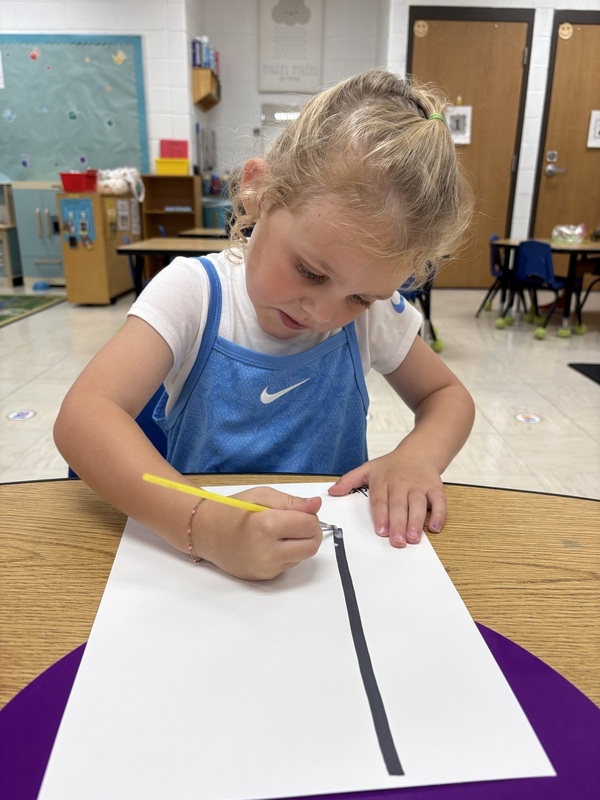 A pre-k student Working on fine motor skills with letters 
