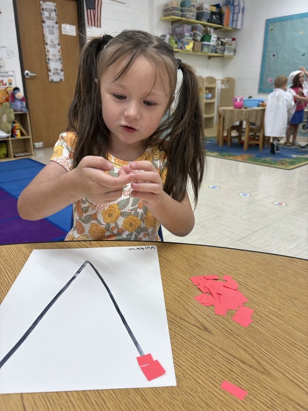 A pre-k student Working on fine motor skills with letters 