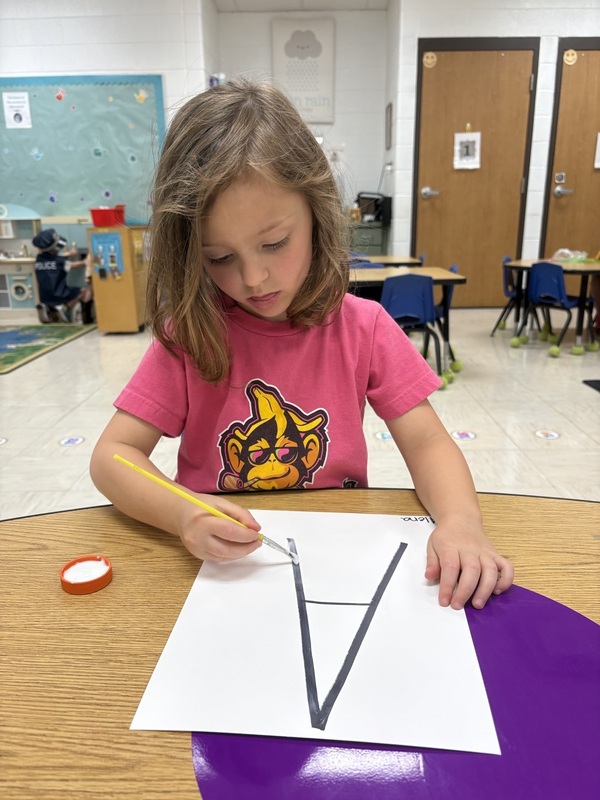 Pre-K student working on fine motor skills tracing letters