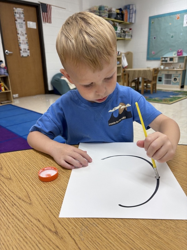 Pre-K student working on fine motor skills tracing letters