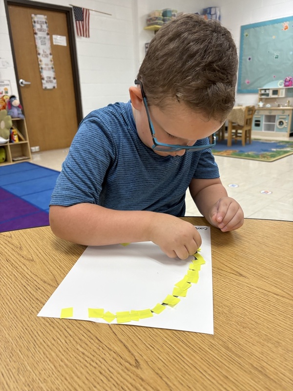 Pre-K student working on fine motor skills tracing letters