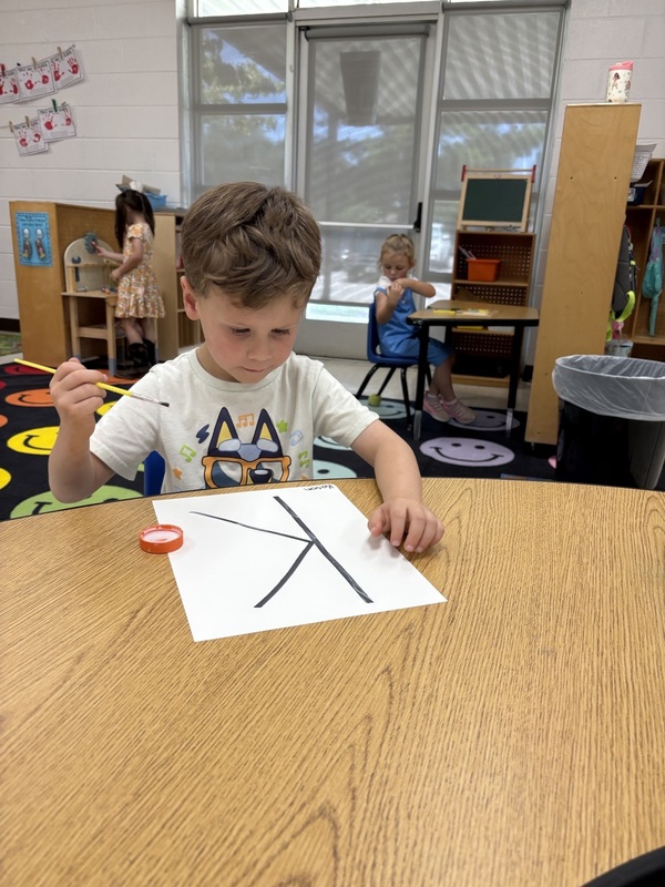 Pre-K student working on fine motor skills tracing letters