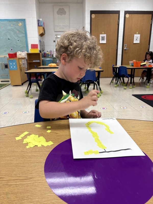 Pre-K student working on fine motor skills tracing letters
