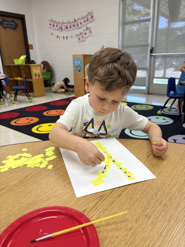 Pre-K student working on fine motor skills tracing letters