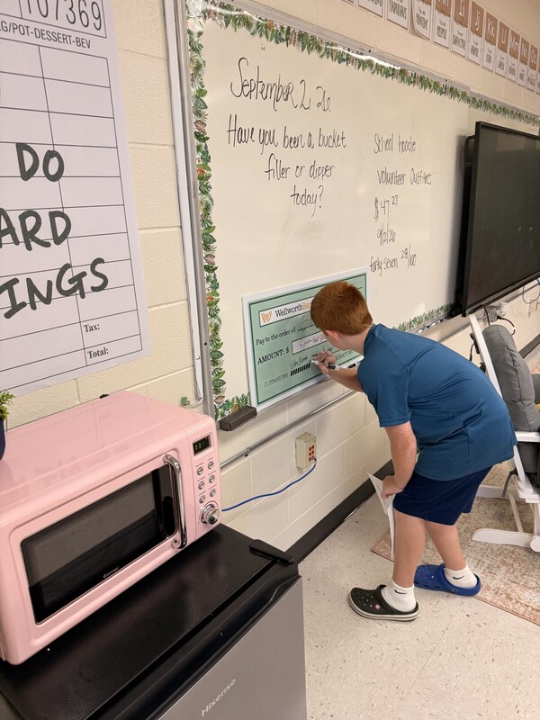 student learning to write a check