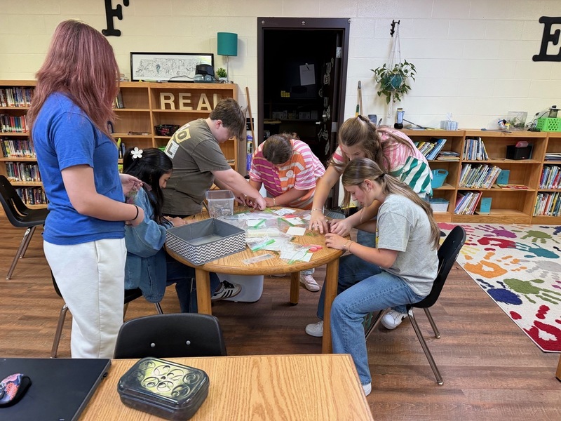 students creating bookmarks with dried flowers