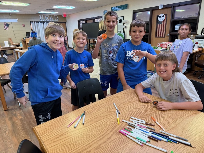 students with their buttons they created in library