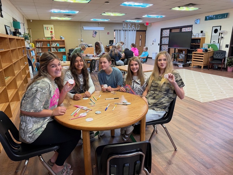 8th grade students creating buttons at library