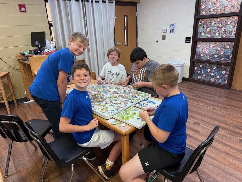 students working together on a puzzle in library