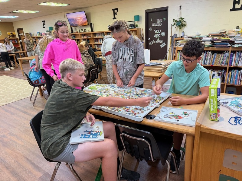 students working together on a puzzle in library