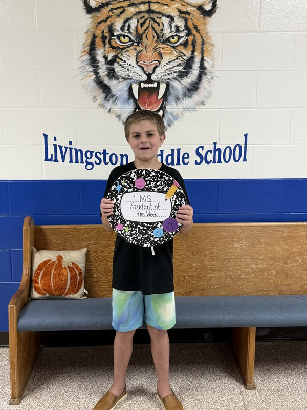 boy holding Student of the Week sign