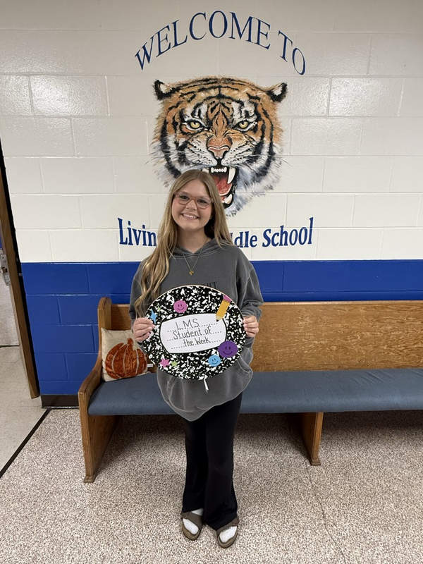 girl holding student of the week sign