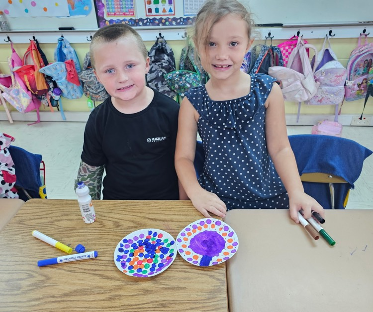 Mrs. Vicky’s students pose with dot art project