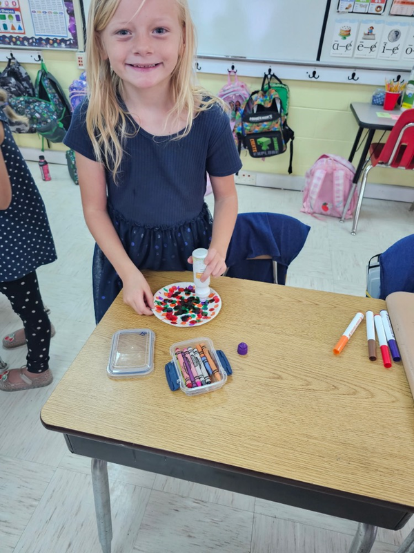 Mrs. Vicky’s students pose with dot art project