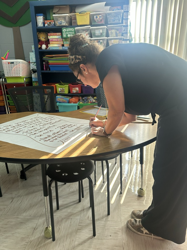 Miss Delk signing the classroom constitution