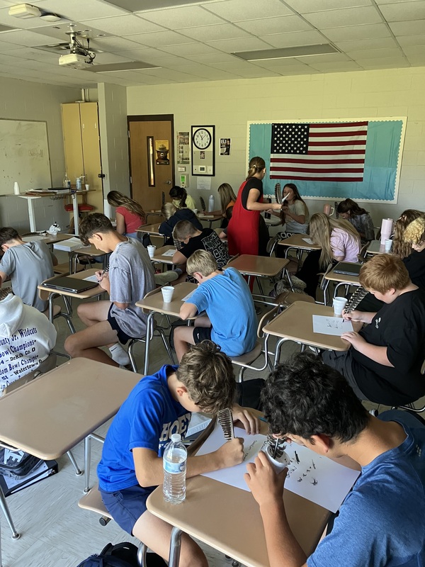 8th grade students write the Constitution with feather pens