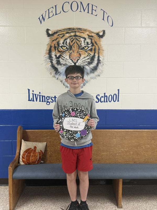 boy with student of the week sign