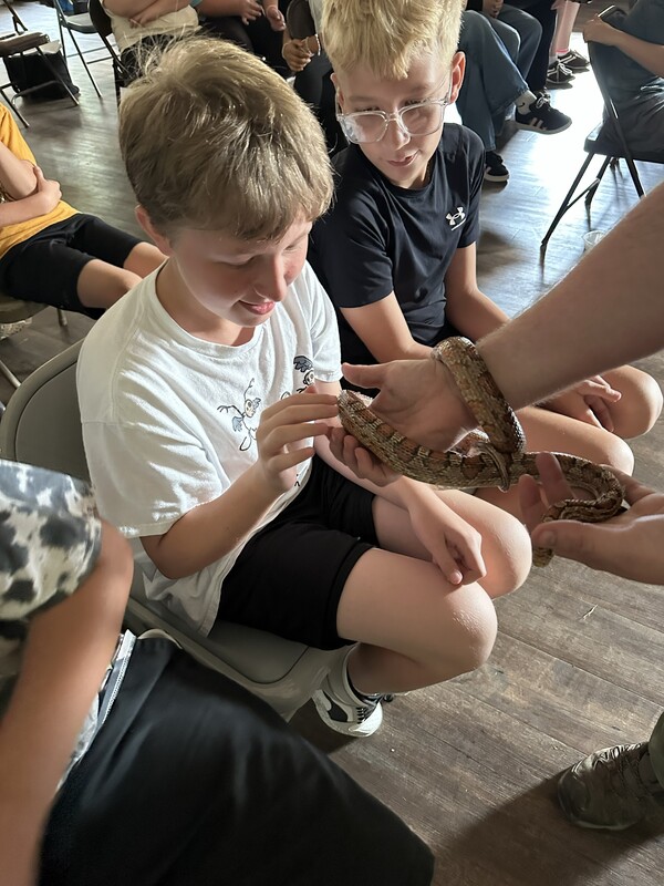 7th grade student touching snake