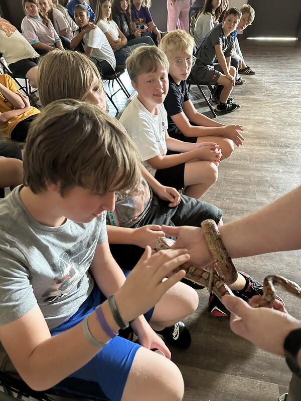 7th grade student touching snake