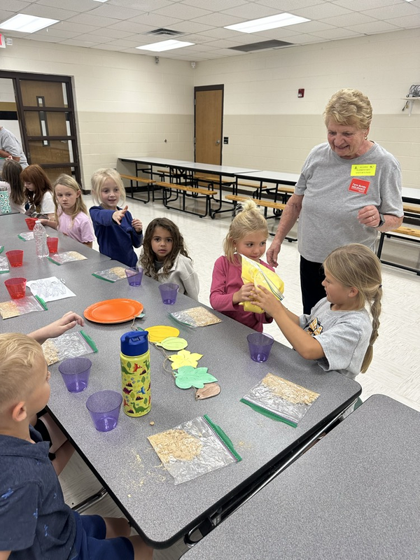 first grade students helping make the pie filling