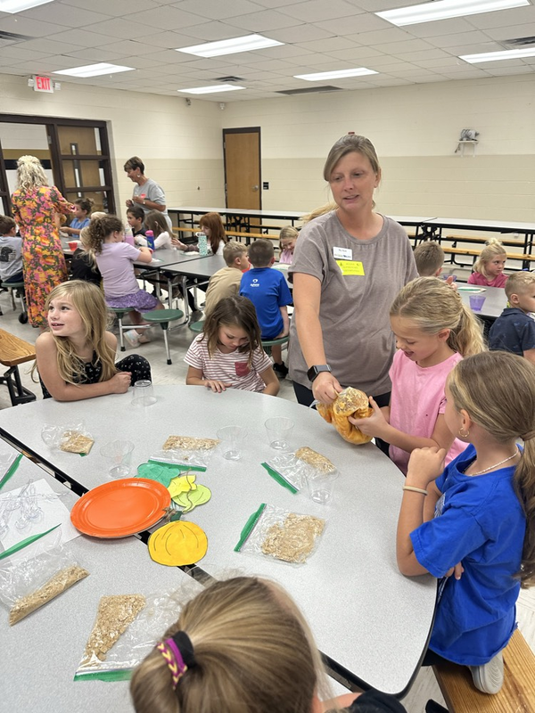 first graders making pumpkin pie in a bag