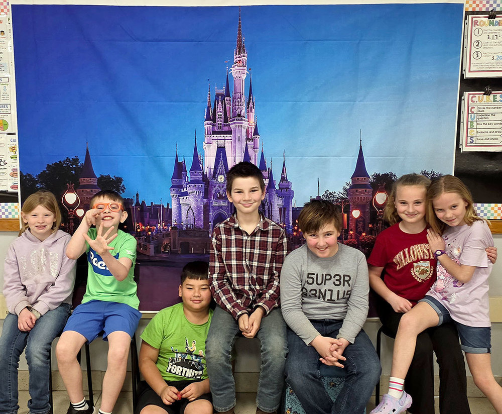 students sit in front of whiteboard projection of iconic Disney World Castle