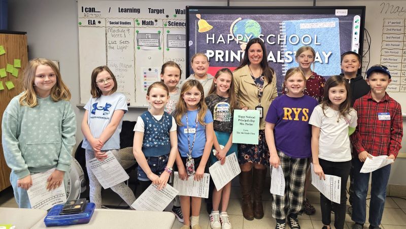 Principal Tucker stands with a group of elementary students