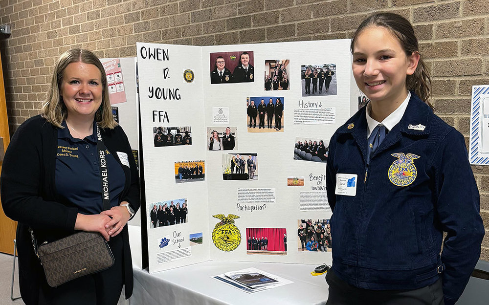 ODY advisor and student stand in front of FFA display