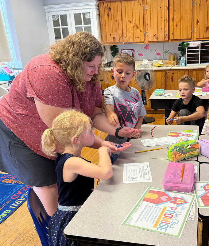 Teacher helps students build bracelets
