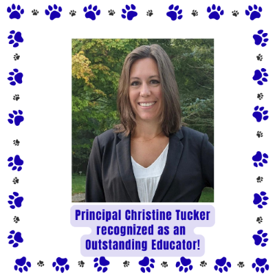 Principal Tucker stands outside with tree and green leaves in background