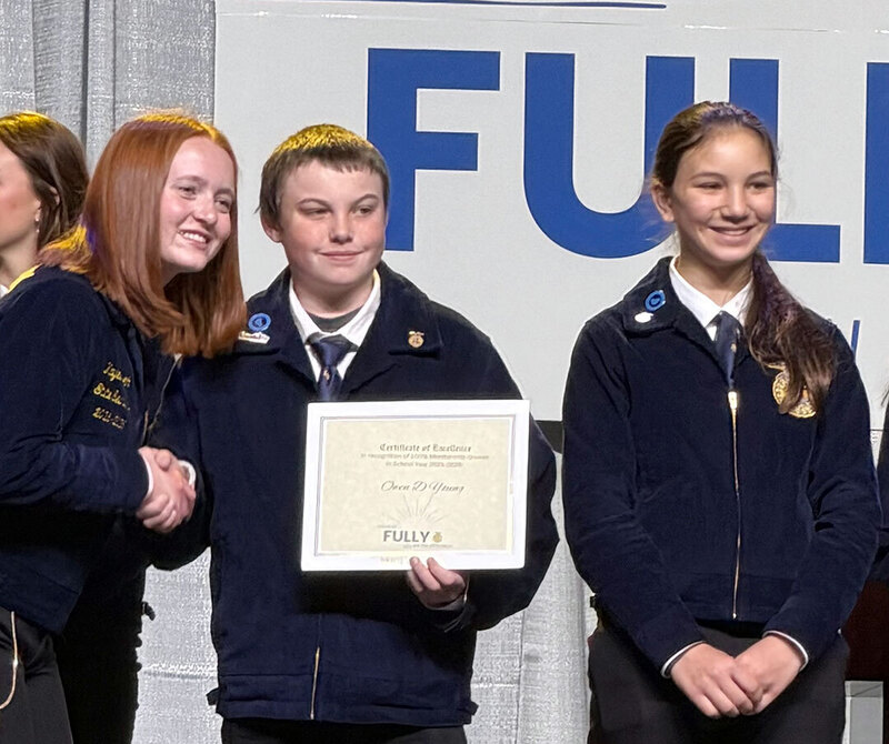 ODY FFA student accepts award as another ODY student stands nearby