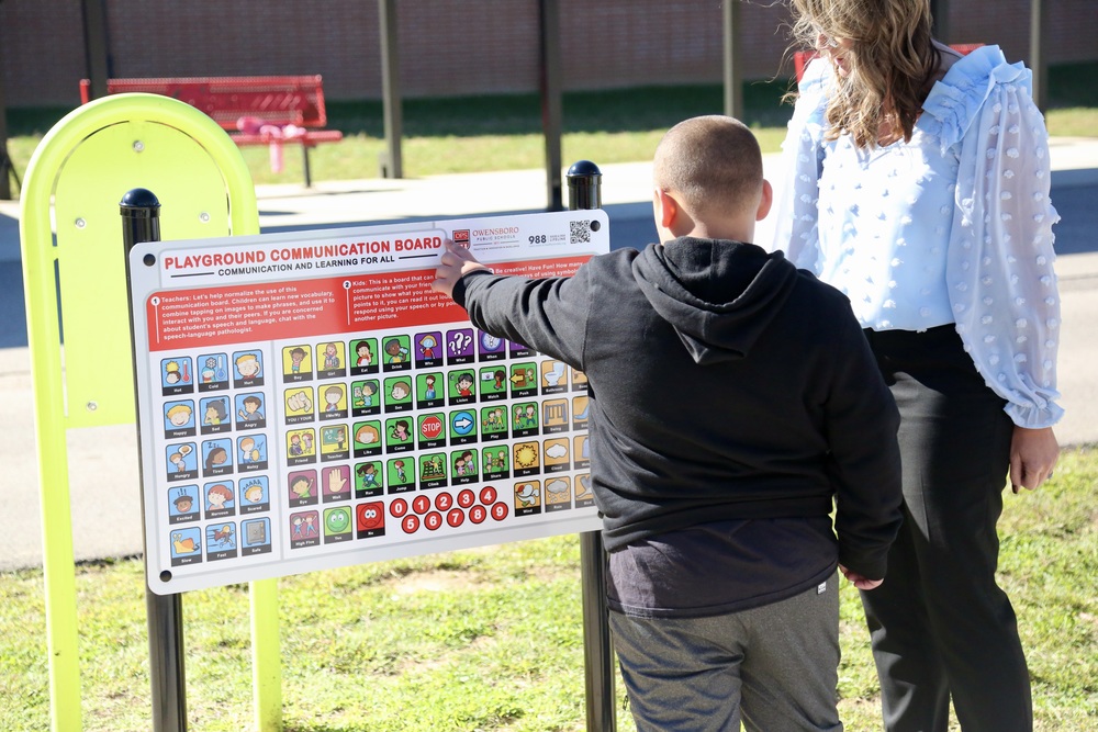 Student pointing at communication board