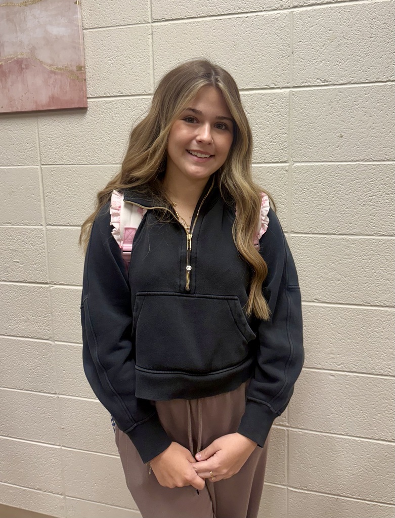A student stands smiling.