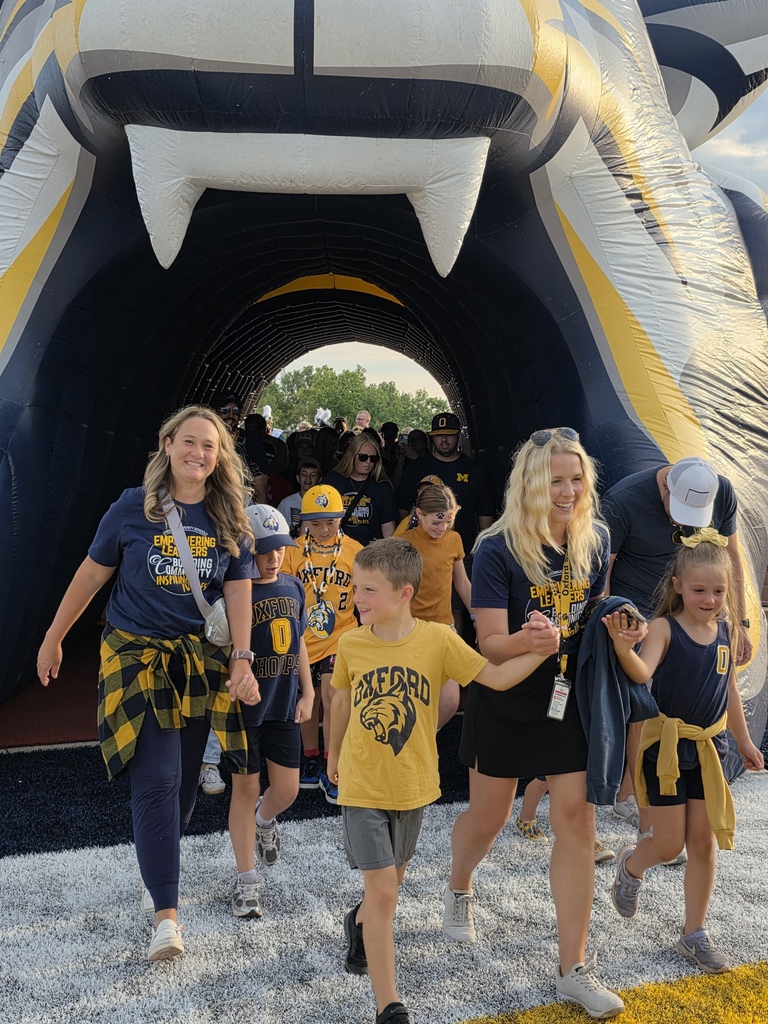 staff walking through the wildcat tunnel onto the football field.
